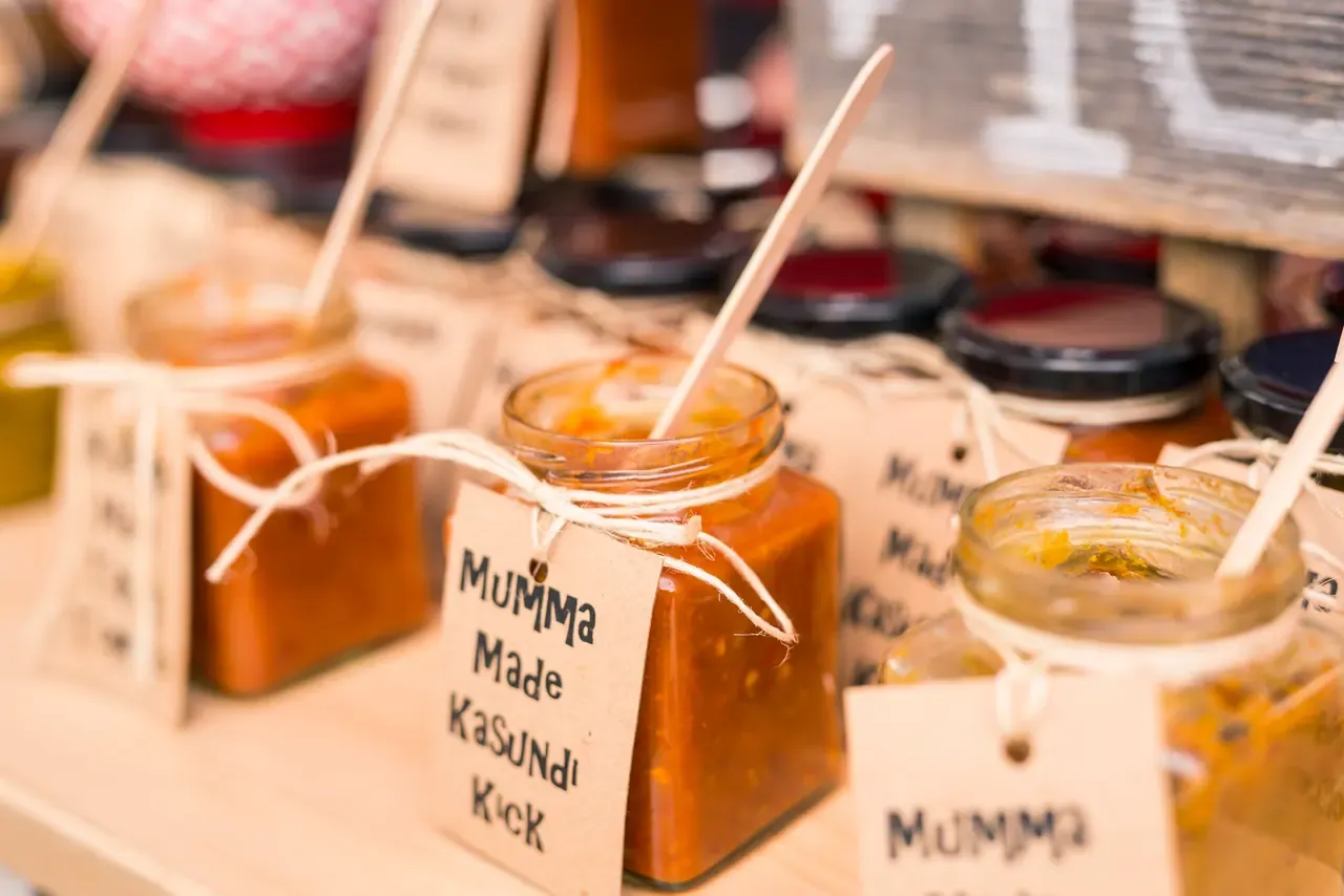 Jars of house-made kasundi and relish tied with string and handwritten tags, each with a wooden tasting stick