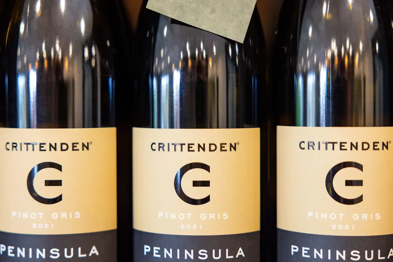 Close-up of three bottles of Crittenden 2021 Pinot Gris lined up side by side, their cream labels facing forward
