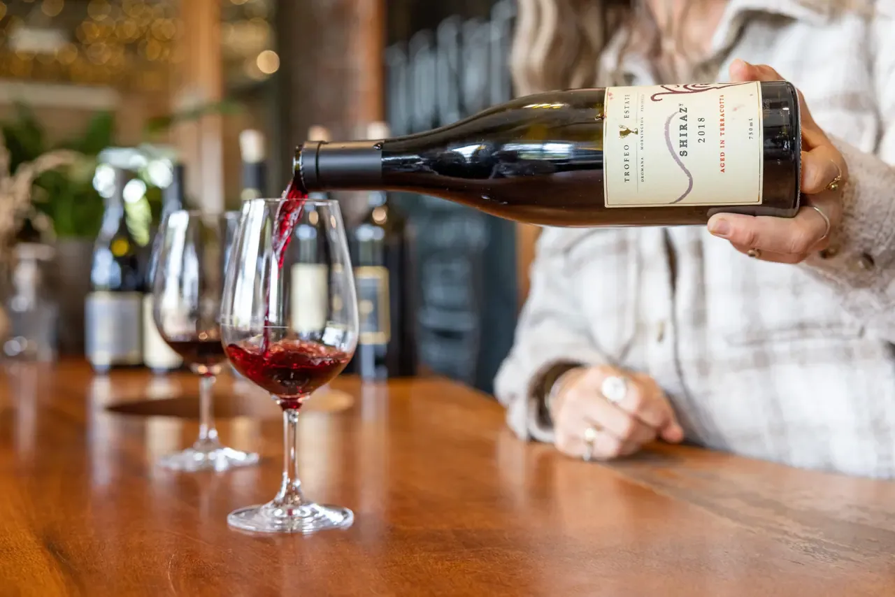 Trofeo Estate Shiraz aged in terracotta being poured into a wine glass on a polished timber bar