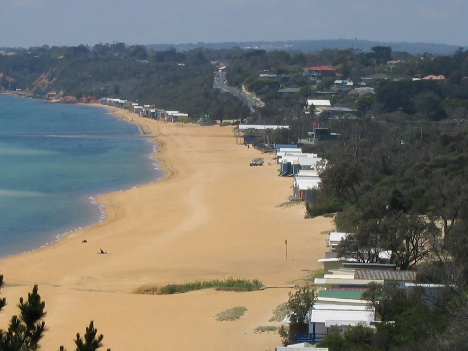Mount Martha beach with bathing boxes at the northern end and the curve of the bay
